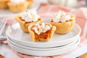 cut open mini pumpkin pies on a white plate