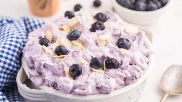 blueberry fluff salad in a white bowl with a blue gingham napkin.