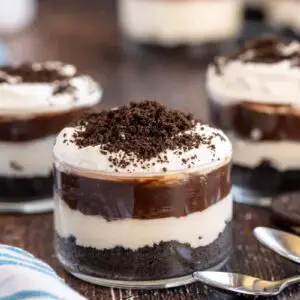 3 oreo dirt puddings in glasses with spoons.