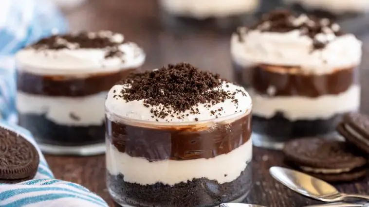 3 oreo dirt puddings in glasses with spoons.